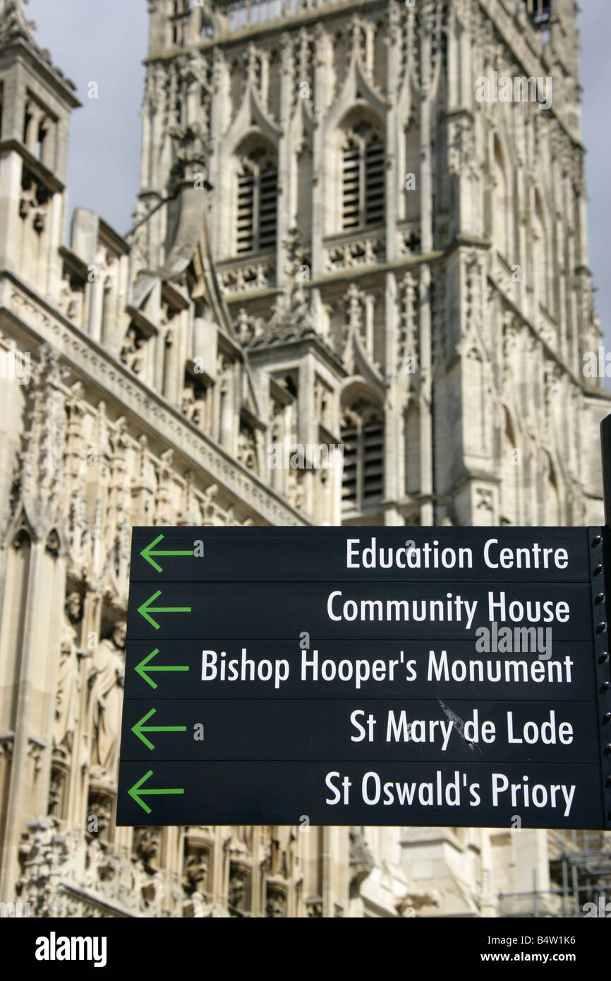 Città di Gloucester, Inghilterra. Direzione di visitatori di firmare il post con la facciata sud della cattedrale di Gloucester in background. Foto Stock