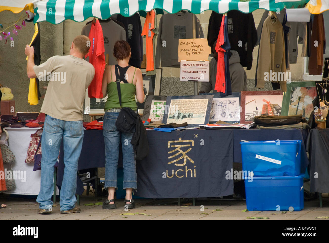People shopping per i vestiti in stallo del mercato, Bristol, Inghilterra, Regno Unito, Europa Foto Stock