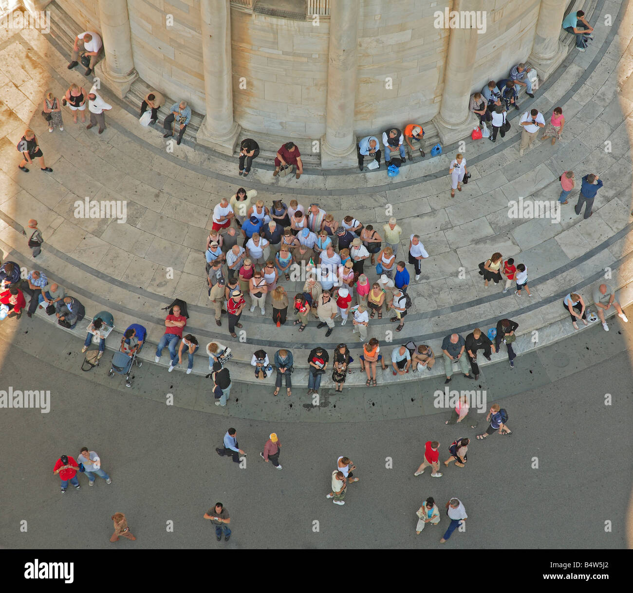 Persone in attesa nell'ombra della Torre di Pisa Pisa Toscana Italia Foto Stock