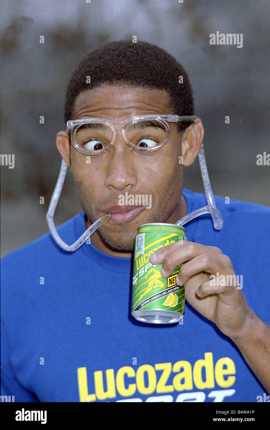 John Barnes calciatore prepararsi a giocare sul continente di bere una lattina di lucozade utilizzando occhiali buffi Febbraio 1991 Foto Stock