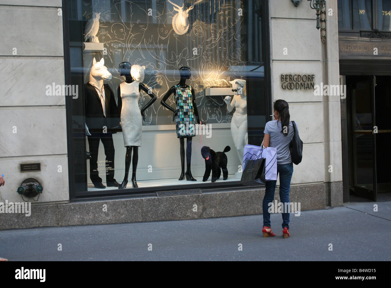 Una donna di window shopping a Bergdorf Goodman, New York, NY. Foto Stock