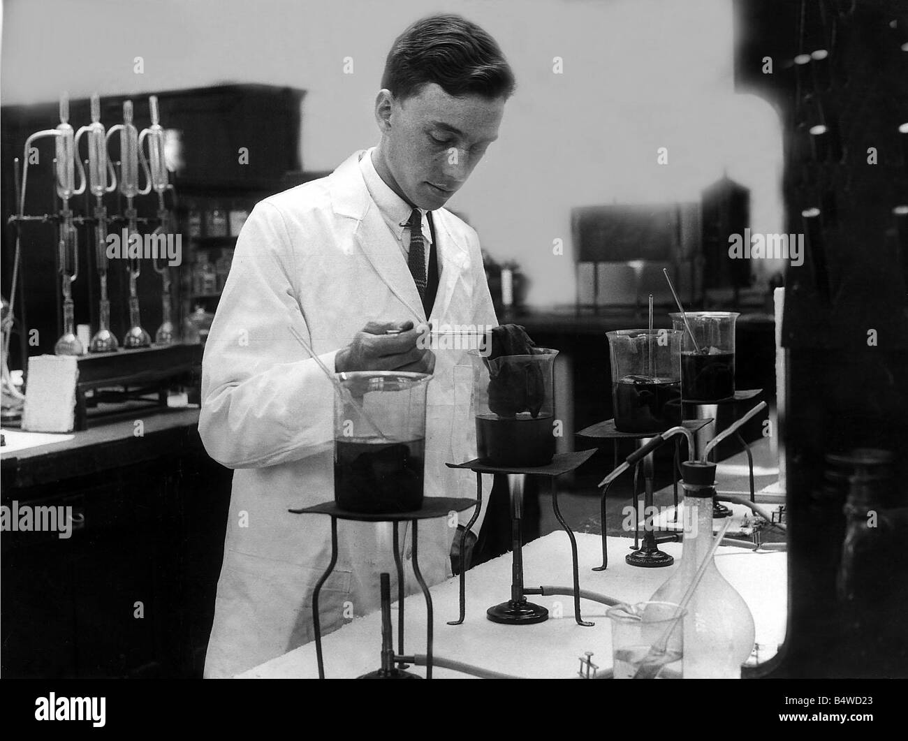 La scienza becco Bunsen Agosto 1926 Un chimico test coloranti sul materiale di lana in laboratorio 1920s Foto Stock