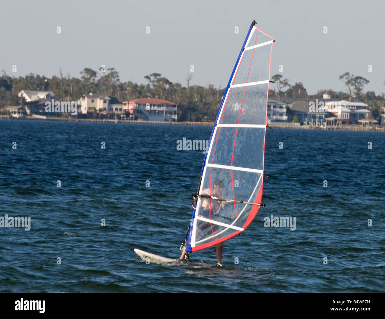 L'uomo la sua barca a vela wind surf a vela nella Baia di Pensacola Beach  Florida giorno caldo e soleggiato con condizioni ventose per l'autunno  Meteo Foto stock - Alamy