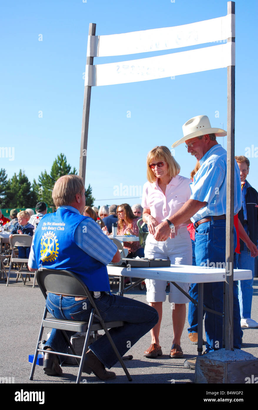 Cowboy e sua moglie acquistando i biglietti per un Rotary club pancake prima colazione Foto Stock