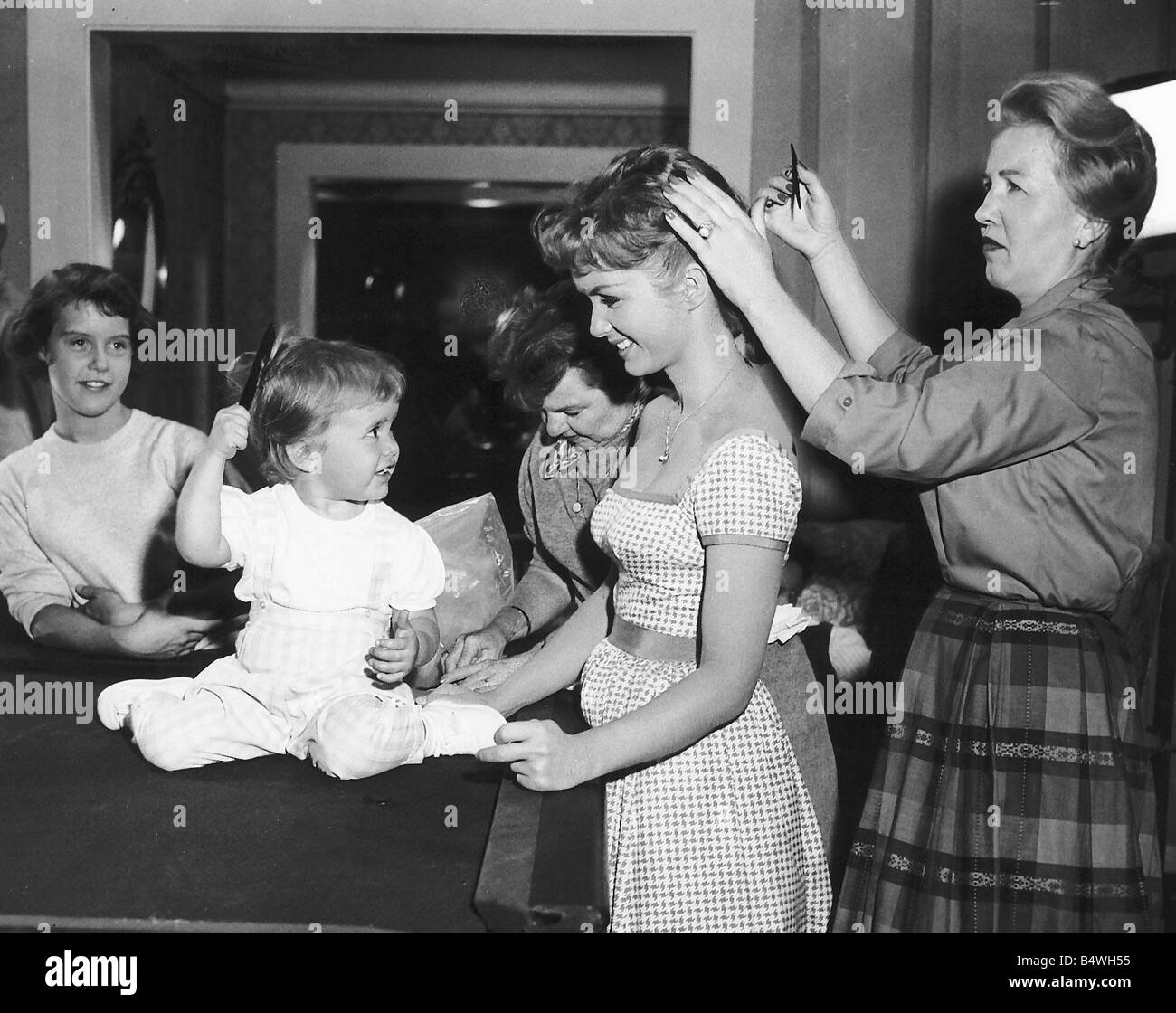 L'attrice Debbie Reynolds ha i suoi capelli fissato tra le scene di MGM s il gioco di accoppiamento nel 1959 piccola figlia Carrie Frances corre un pettine attraverso la sua propria tresses Foto Stock