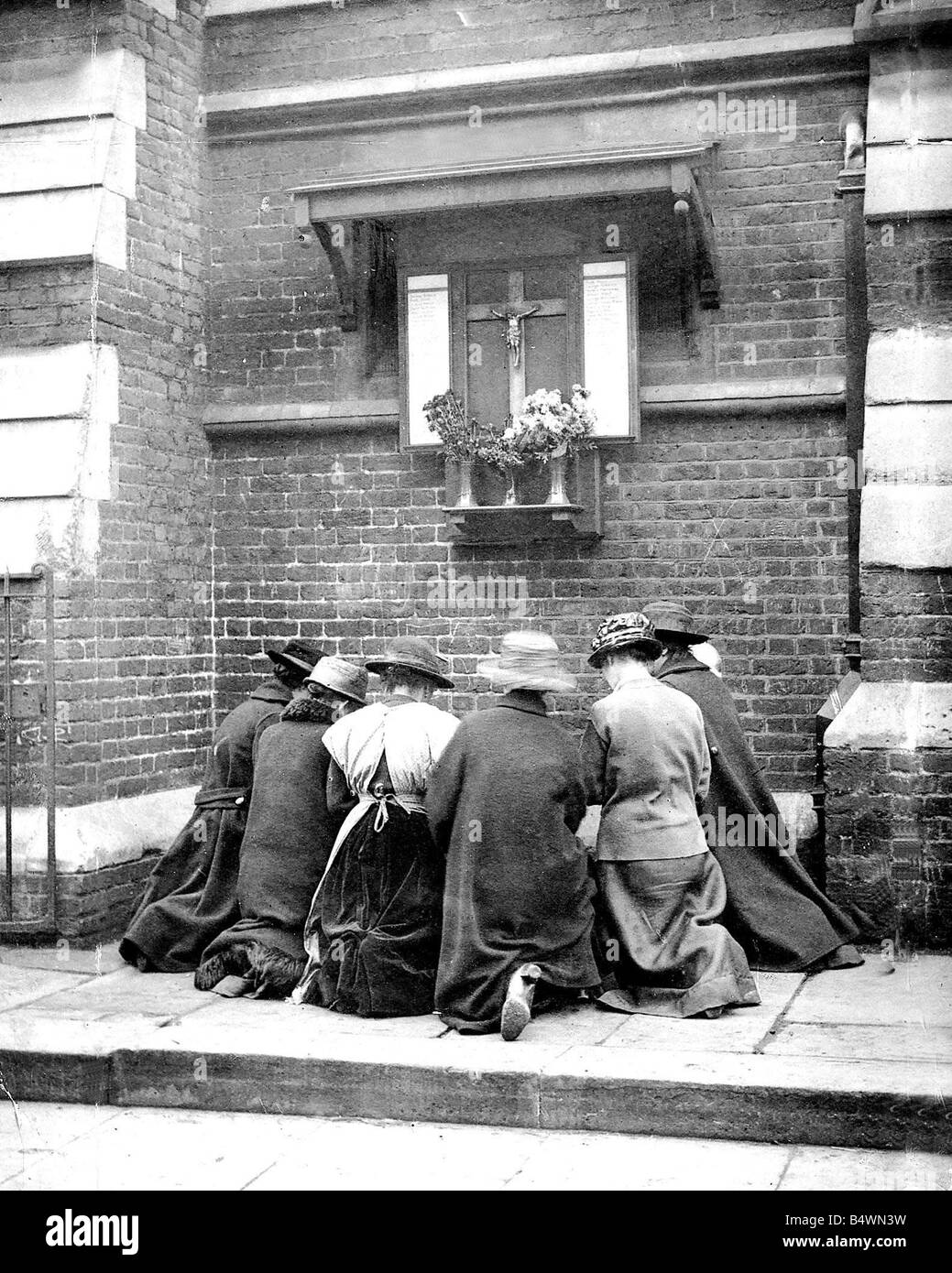 Le donne si inginocchia davanti a Santuario di strada su rememberence 1919 giorno per pagare gli aspetti a soldati persi Foto Stock