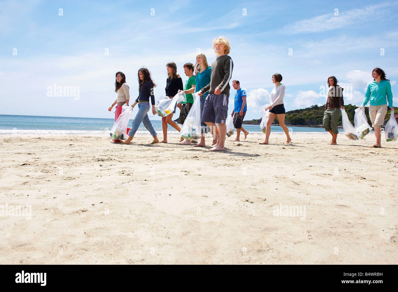 Giovani raccogliere rifiuti sulla spiaggia Foto Stock