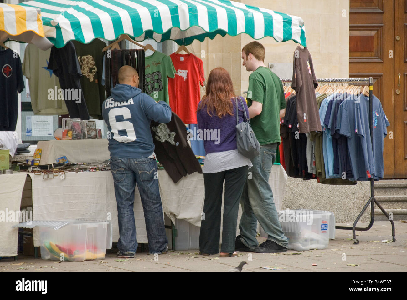 People shopping per i vestiti in stallo del mercato, Bristol, Inghilterra, Regno Unito, Europa Foto Stock