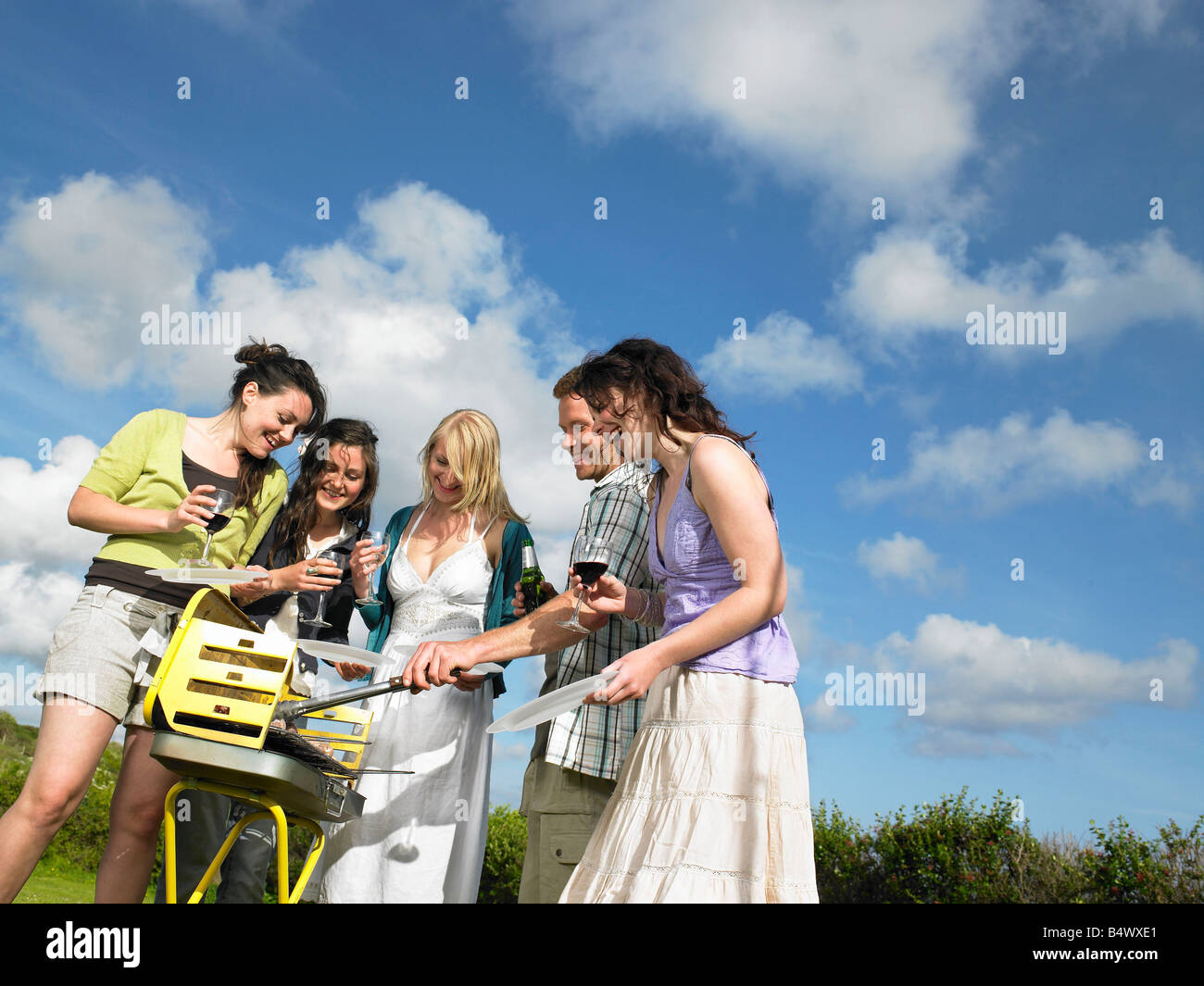Un gruppo di giovani intorno ai barbecue Foto Stock