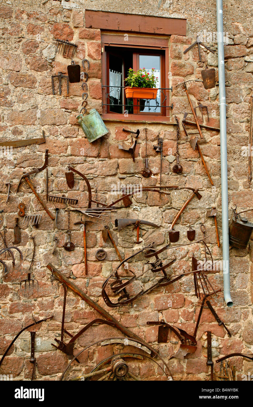 Antichi attrezzi rurali in un antico muro di una casa. Prades (Tarragona)  Catalogna Spagna Foto stock - Alamy
