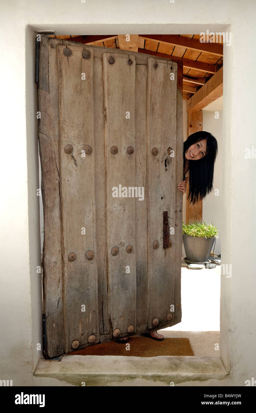 Donna di apertura della porta anteriore Foto Stock