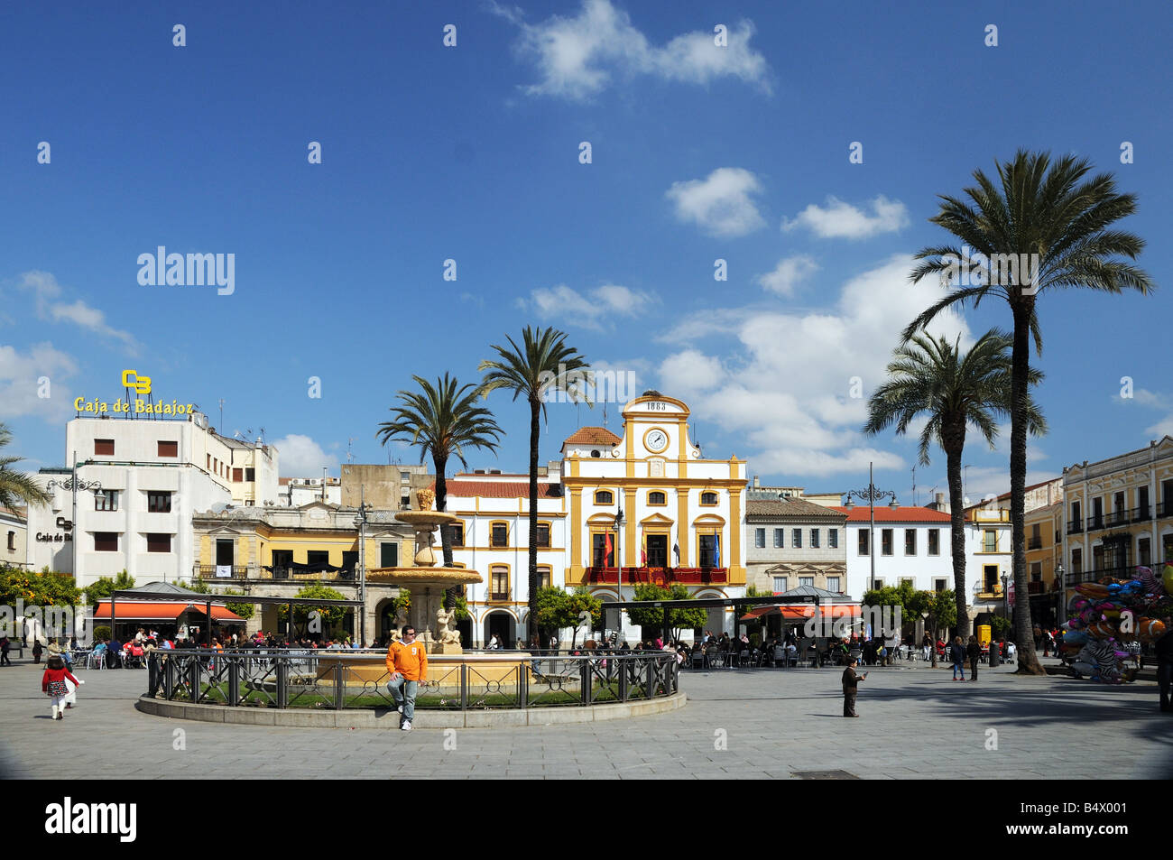 Plaza de Espana Merida Extremadura Spagna con palme e le persone che si godono il sole primaverile Foto Stock