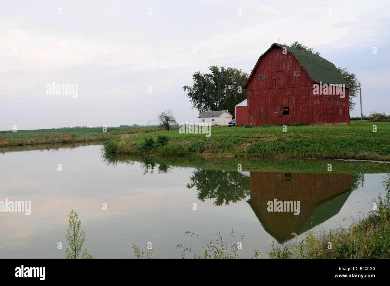 Il vecchio granaio rosso riflettente nel laghetto Illinois usa Foto Stock