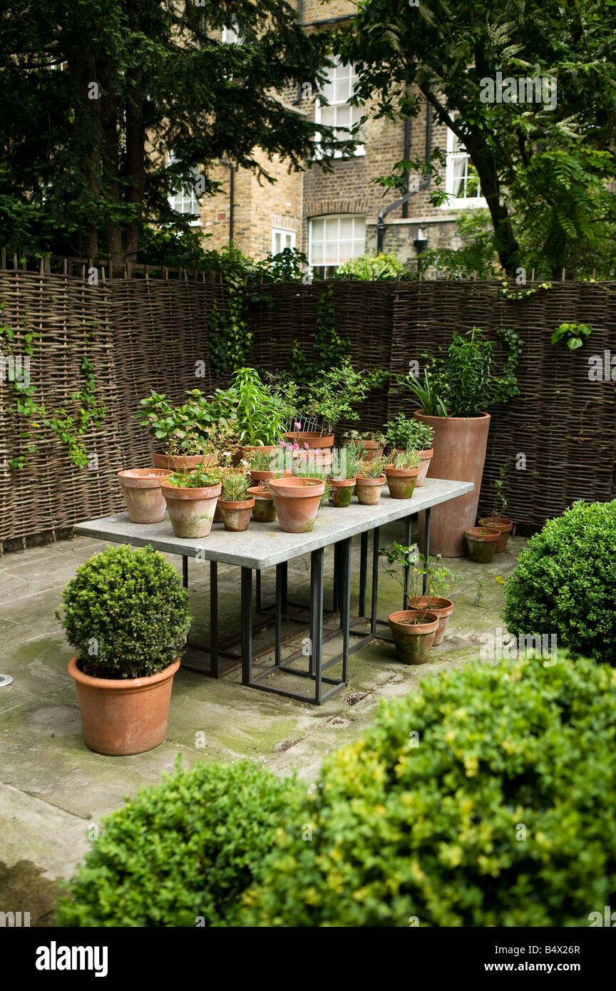 Tavolo da giardino con piante e vasi per piante Foto Stock