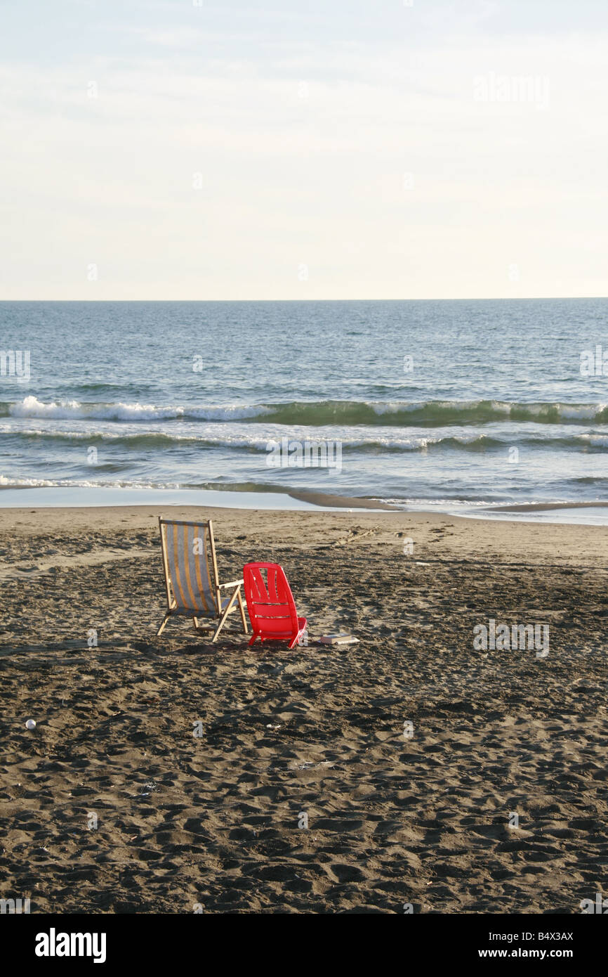 Due sedie vacanti posti sulla spiaggia deserta di Sun Foto Stock