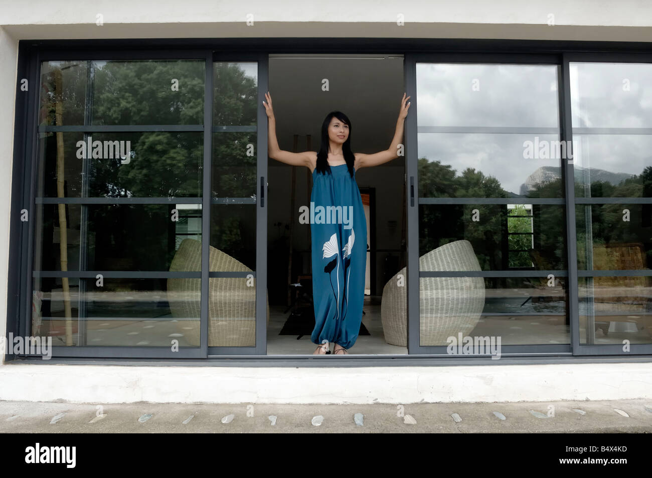 Donna di apertura della porta anteriore Foto Stock