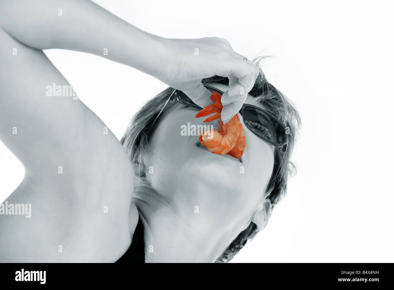 La donna è in possesso di due gamberetti nella sua bocca Foto Stock