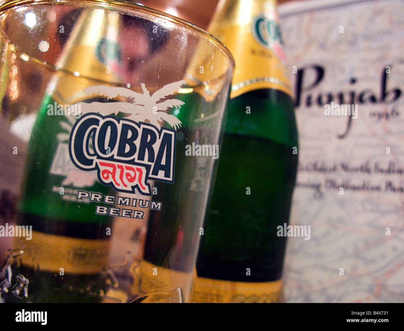 Cobra bicchiere di birra e una bottiglia in un ristorante indiano Foto Stock