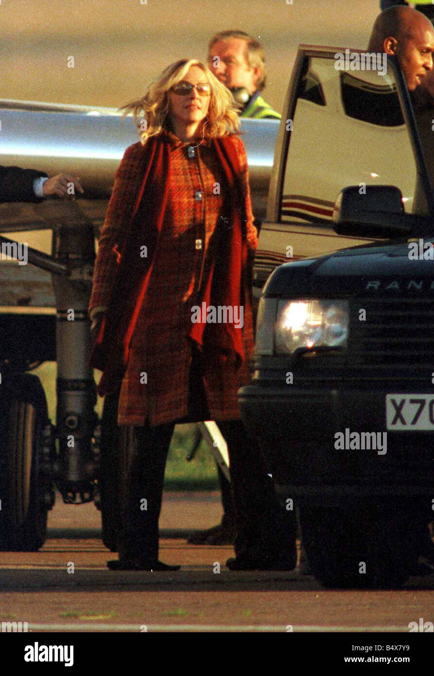 Madonna arriva all'aeroporto di Inverness Dicembre 2000 wearinf arancione cappotto tartan sciarpa occhiali da sole Foto Stock