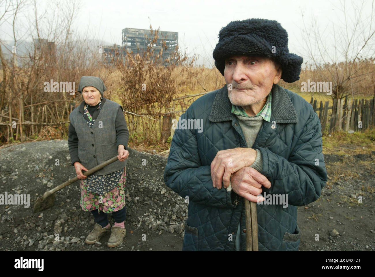 Copsa Mica Romania Novembre 2006 Copsa Mica Europa s più inquinato posto Teodor Indre 86 e sua moglie Aurelia rammendo la strada al di fuori della loro casa nella parte anteriore della vecchia fabbrica di carbonio Foto Stock