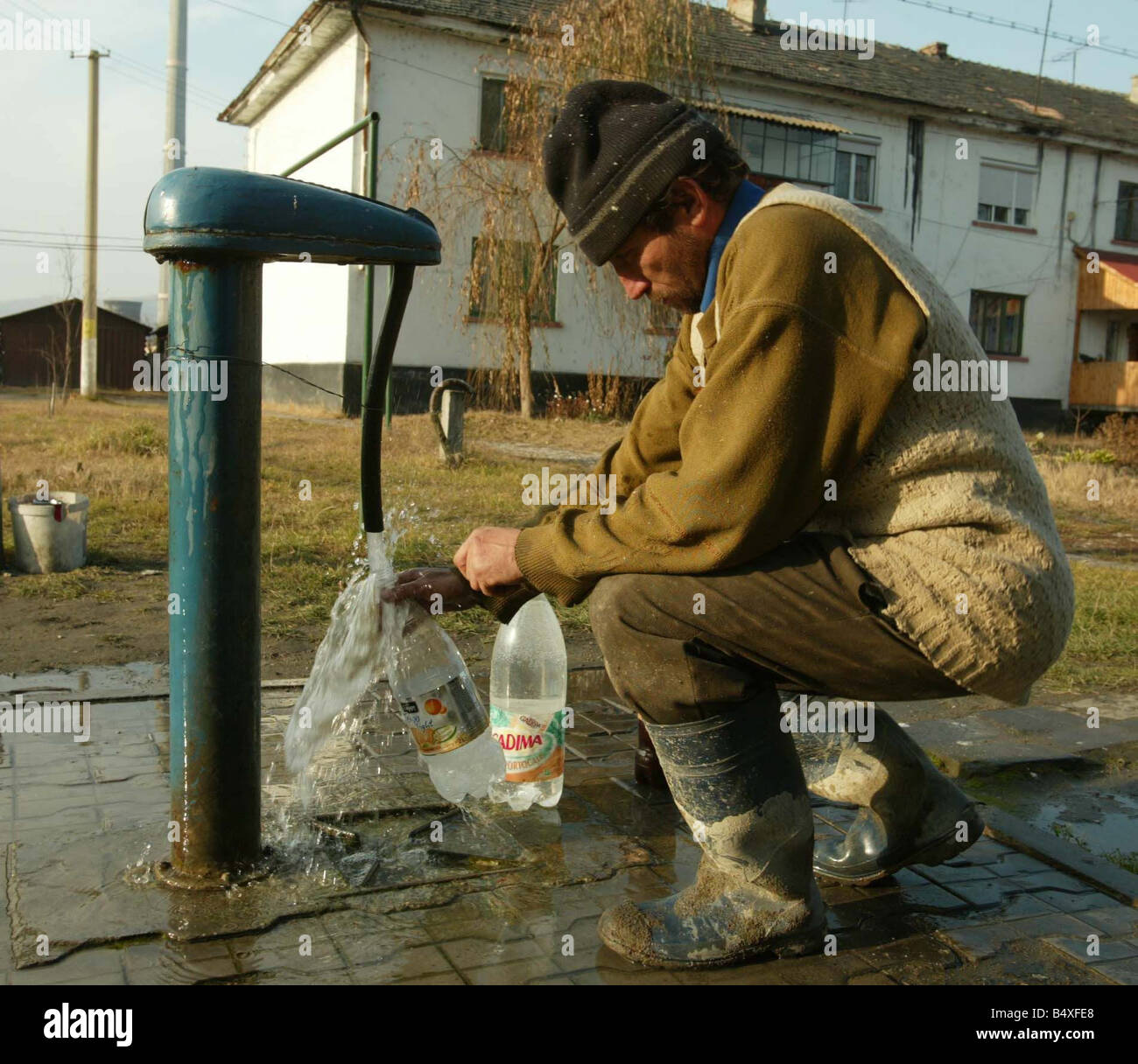 Copsa Mica Romania Novembre 2006 Copsa Mica Europa s più inquinato posto un uomo si riempie il suo bottiglie di acqua dal rubinetto locale l'acqua è contaminata Foto Stock