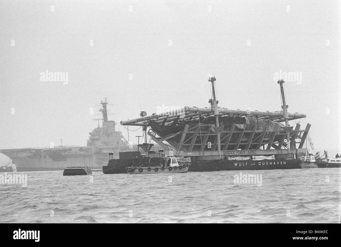 Il sollevamento del Mary Rose Ottobre 1982 Re Enrico VIII ammiraglia della Mary Rose sulla sua chiatta salvage trainato a Portsmouth dopo essere stata sollevata dal mare cordone di Southsea visto qui passando il vettore airtcraft baluardo HMS Foto Stock