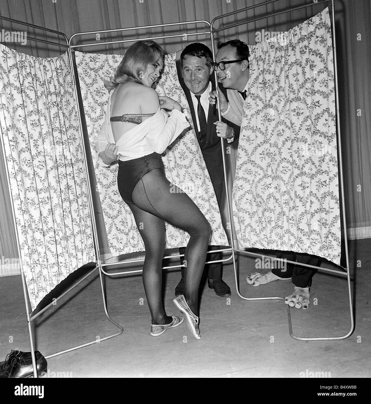 Eric Morecambe e Ernie Wise Giugno 1965 clown it up spiata attraverso le tende a metà vestito lady chorus girl Valerie Barrett Foto Stock
