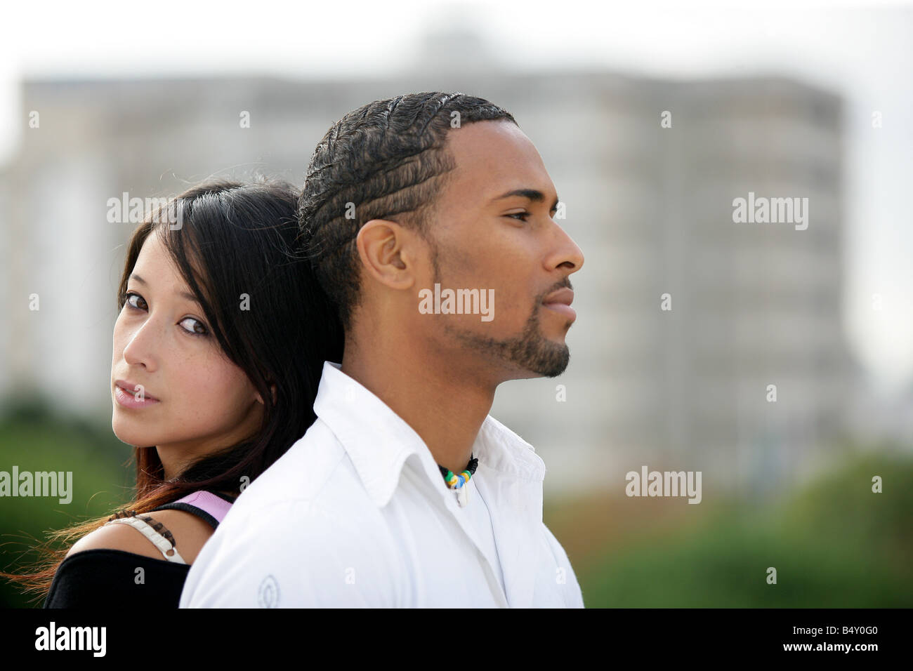 Coppia giovane di fronte agli edifici Foto Stock