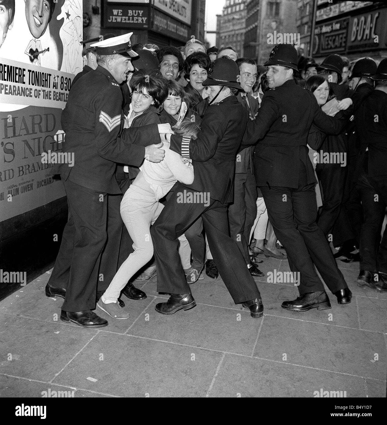 Gruppo pop The Beatles Luglio 1964 Paul McCartney Ringo Starr John Lennon George Harrison Beatles Premiere del film di una dura giornata s notte al London Palladium la polizia che trattiene la folla di tifosi che sono in attesa di vedere i Beatles Foto Stock