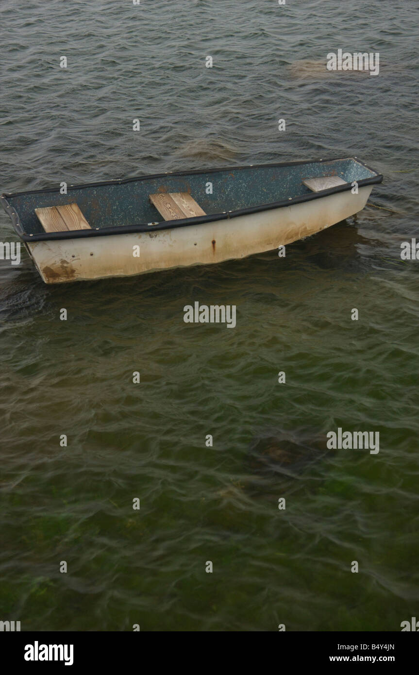 Un vecchio vuoto canotto floating off shore. Foto Stock