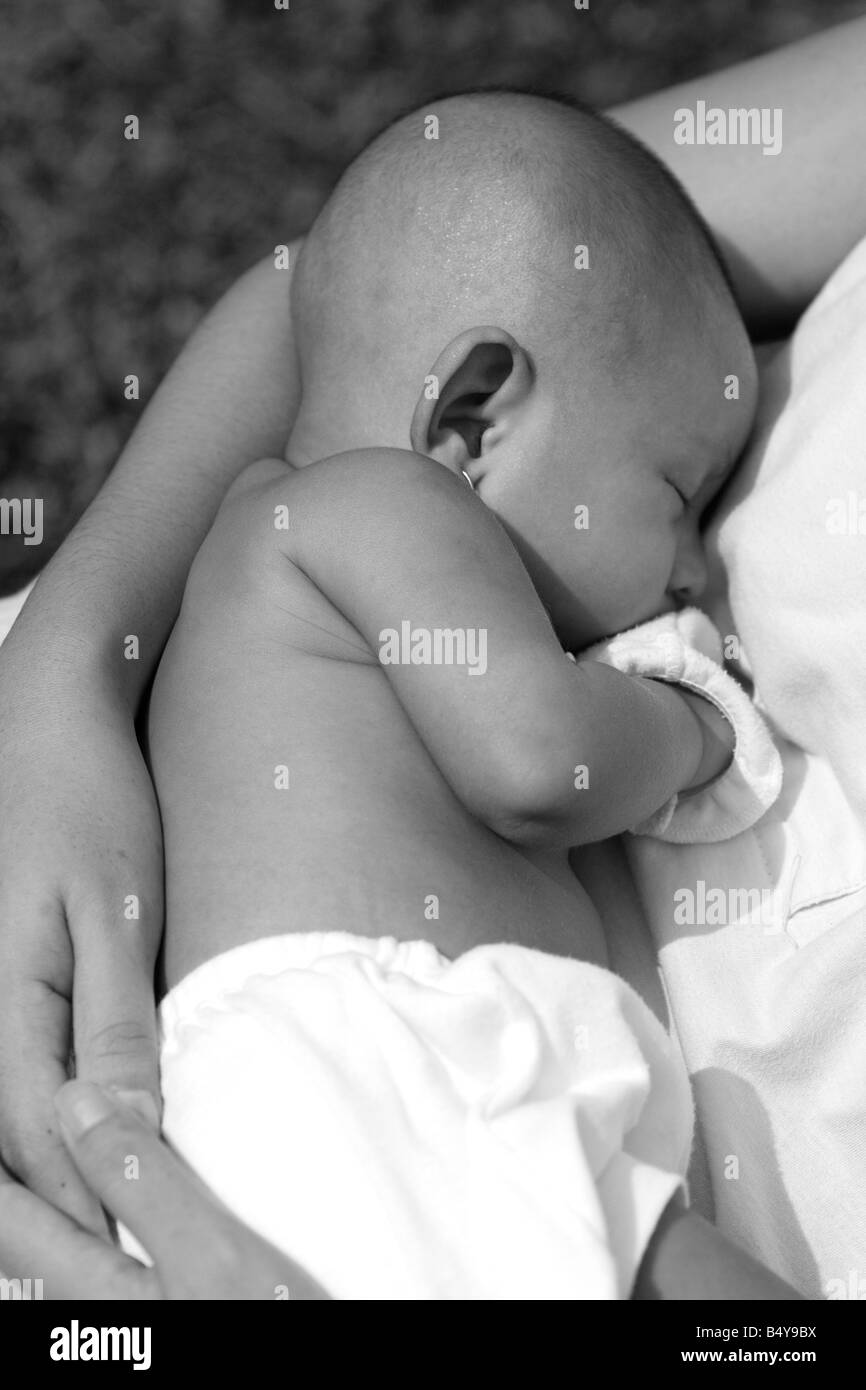 1 mese fa il bambino dorme sul padre durante il giro per prendere il sole Foto Stock