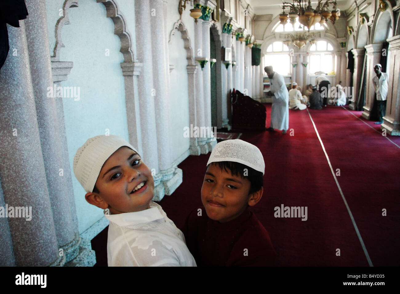 Due ragazzi musulmani abbracciare ogni altro in occasione di Eid al-Fitr (fine del Ramadan) all'interno della moschea di Kathmandu, Nepal Foto Stock