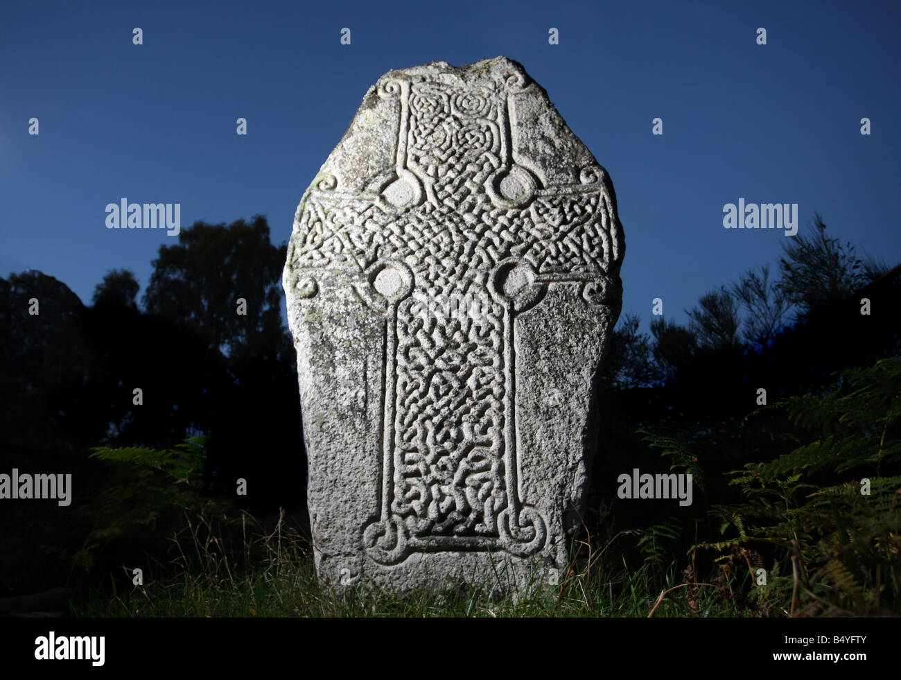 Antica lastra di pietra scolpita con croce celtica design, sulle rive di Loch Kinord in Aberdeenshire, Scotland, Regno Unito Foto Stock