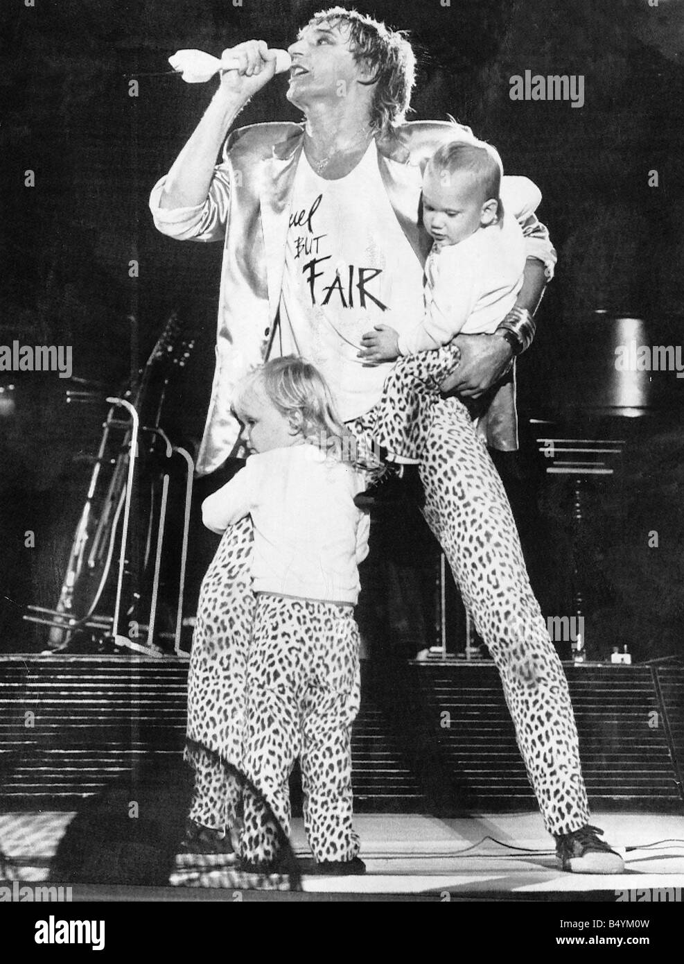 Rod Stewart cantante cantante rock sul palco microfono con i bambini Foto Stock
