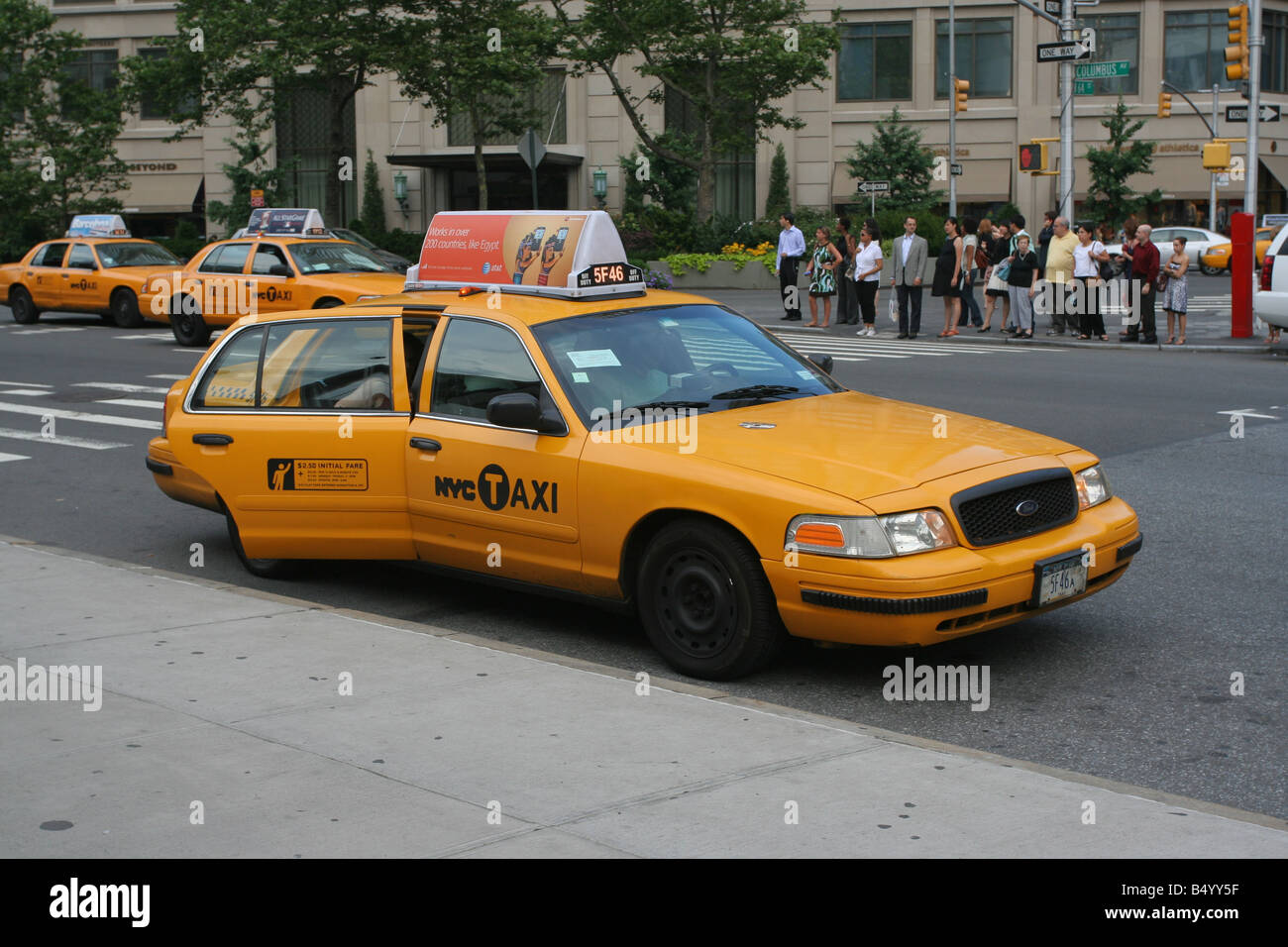 Un taxi giallo di New York City sul marciapiede con altri taxi sullo sfondo nell'Upper West Side di Manhattan Foto Stock