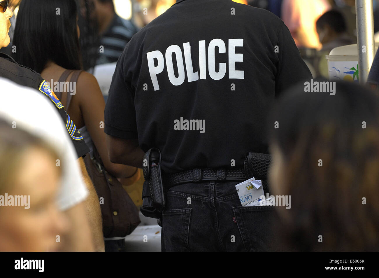 Gli ufficiali di polizia pattuglia della folla in una via pubblica manifestazione fieristica in California Orange Foto Stock