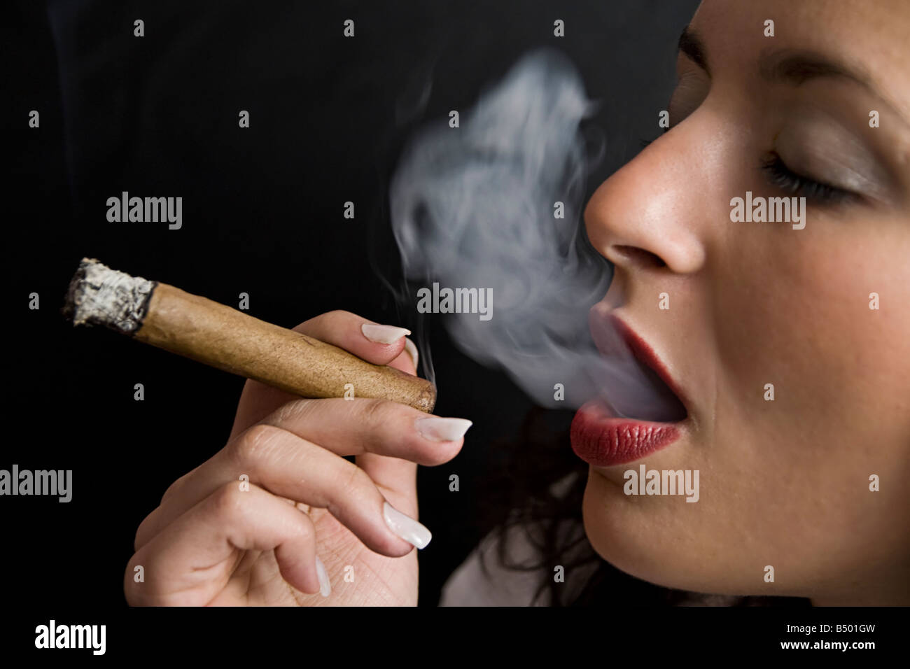 Una donna di fumare il sigaro Foto Stock