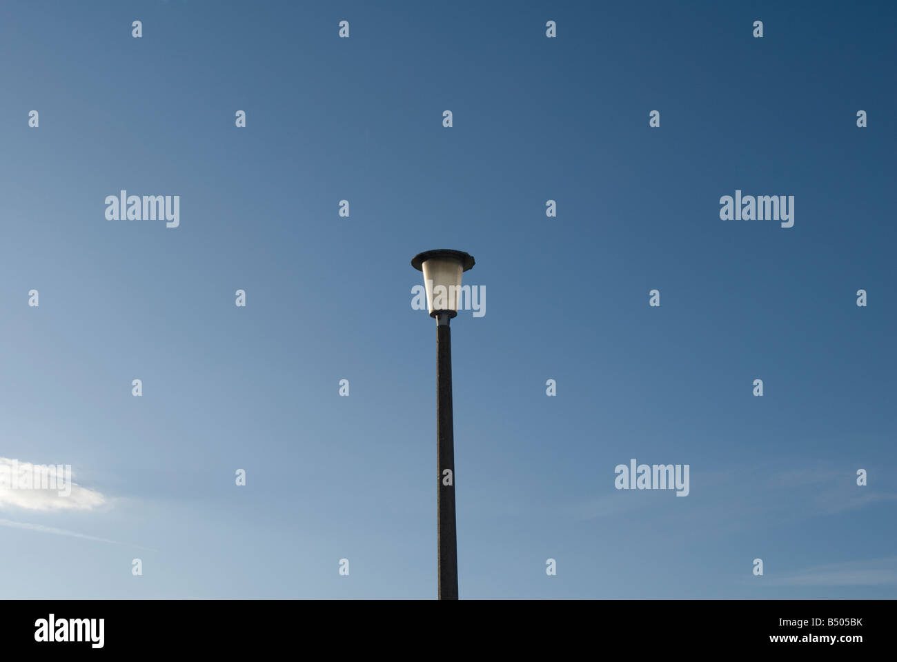 Una lampada posta al centro di un cielo blu sullo sfondo Foto Stock