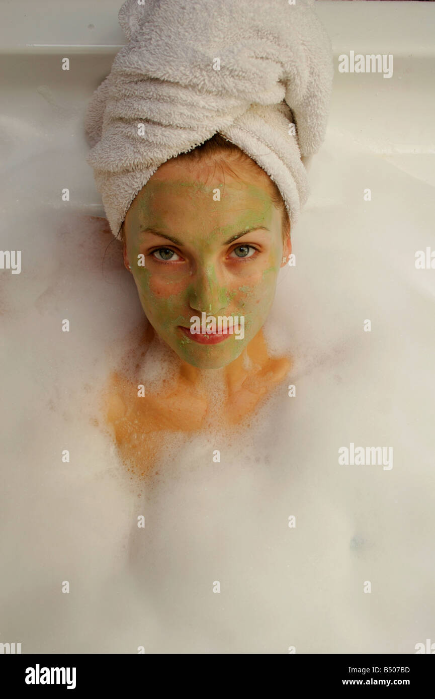 Un attraente ragazza rilassante in un bagno di bolle Foto Stock