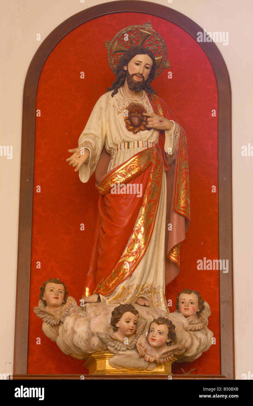 Statua di Gesù Cristo e del sacro cuore con angeli ai suoi piedi Foto Stock