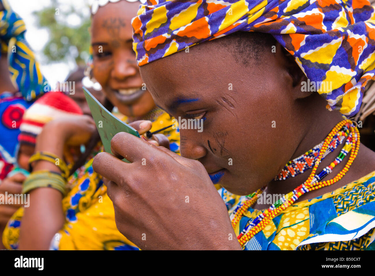 Il 13 luglio 2007 Una giovane donna Fulani in Bele Kwara Niger si applica il trucco blu per il suo volto Foto Stock