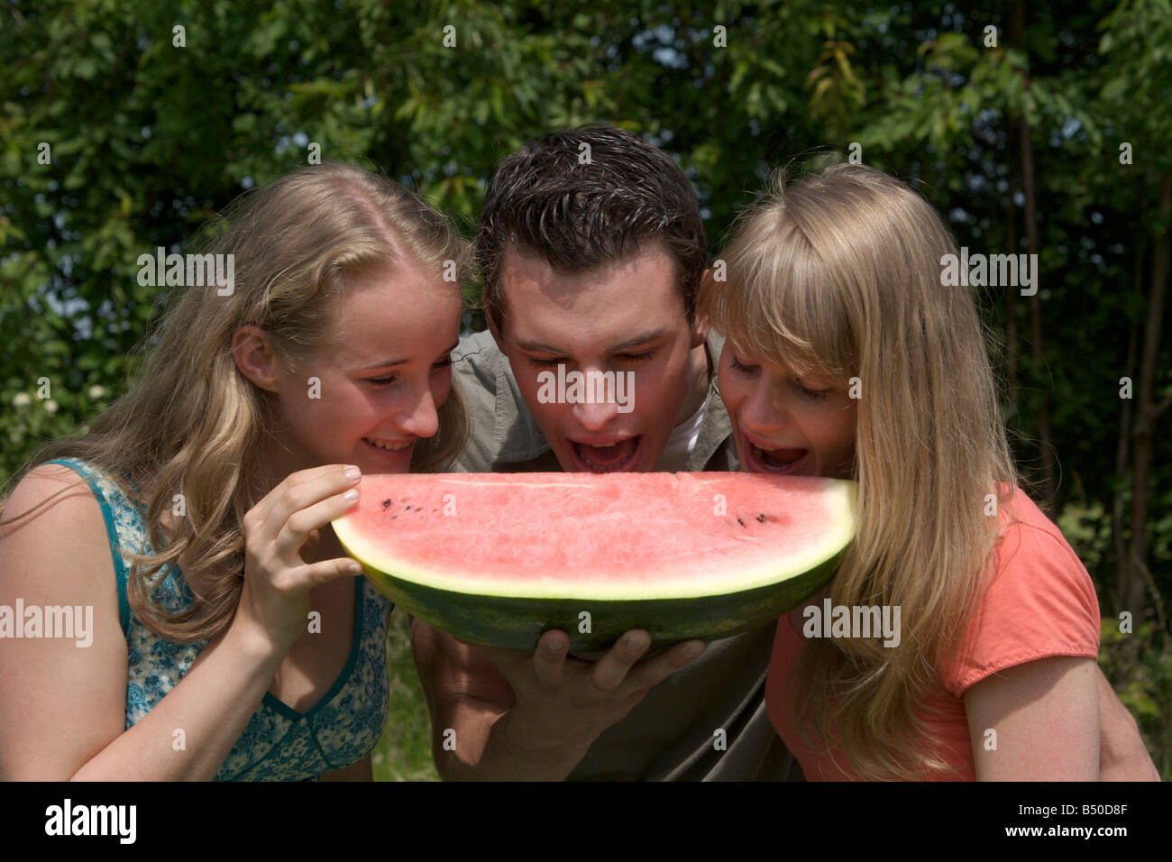 Tre amici mangiare un Water melon - Drei Freunde essen eine Melone Foto Stock