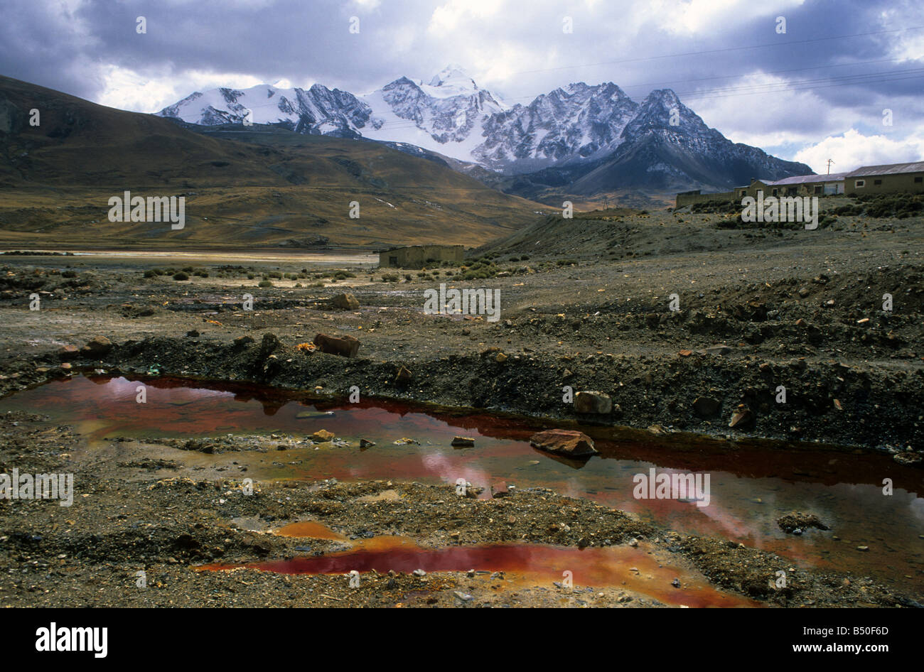 Contaminazione da drenaggio acido delle miniere e rifiuti industriali provenienti dalla vicina miniera di stagno a Milluni, Monte Huayna Potosi in background, vicino a la Paz, Bolivia Foto Stock