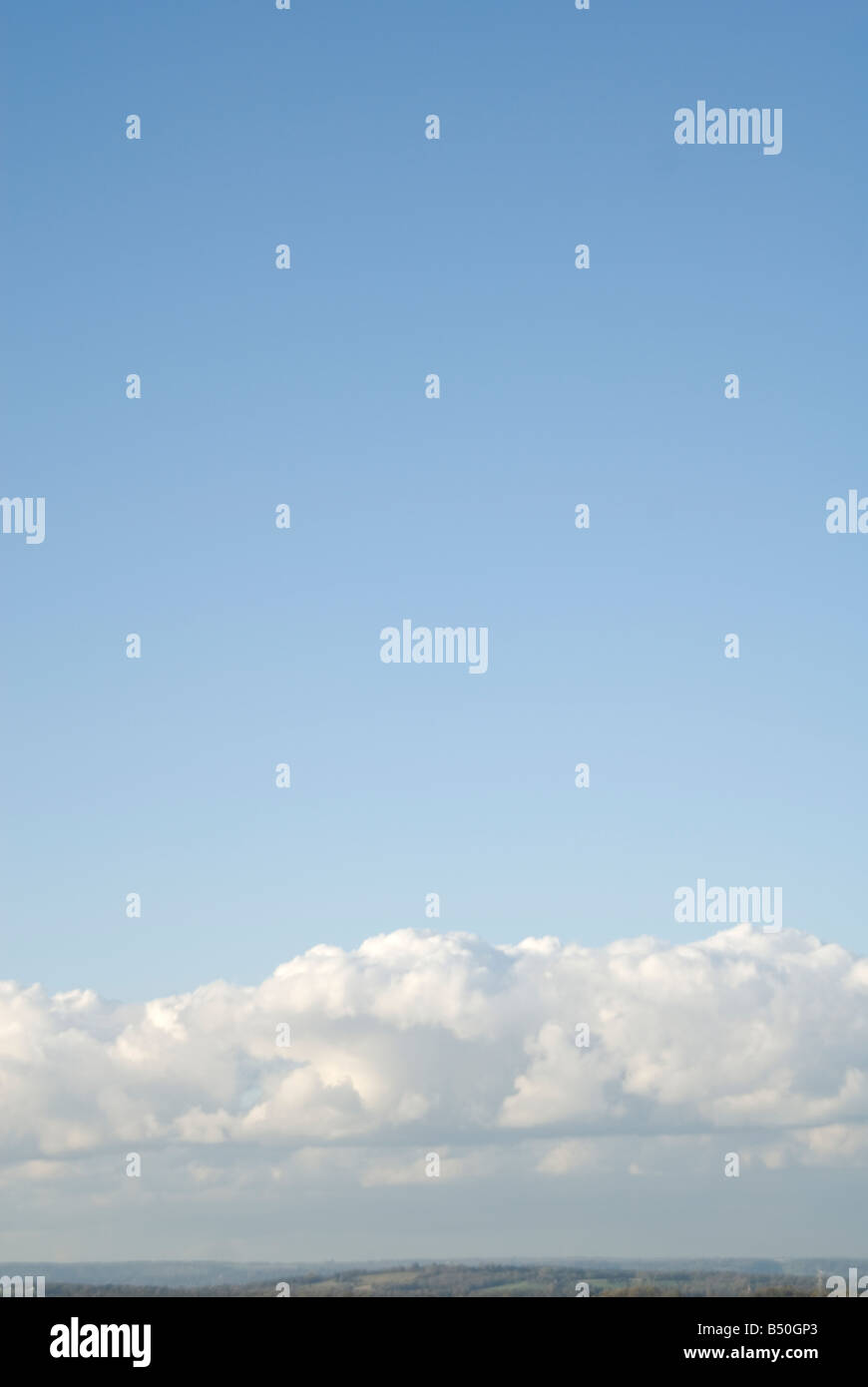 Una vista del cielo blu con nuvole andando di fronte alla parte inferiore dell'immagine e mostrare un po' di Ashdown Forest in fondo Foto Stock