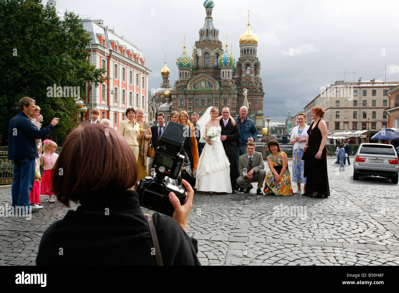 Le persone che posano per una foto davanti alla chiesa del sangue versato a San Pietroburgo Russia Foto Stock