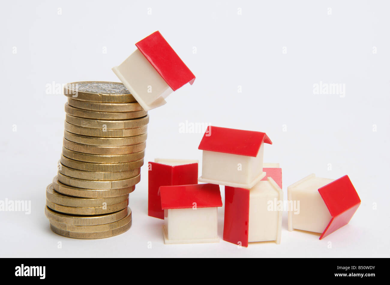 Casa in miniatura sulla pila di monete, immagine simbolica real estate Foto Stock