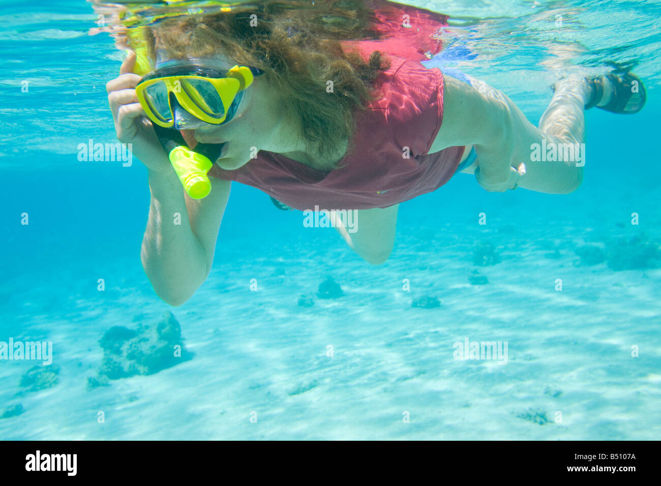 Una donna di fare snorkeling lungo la barriera corallina vicino a Dahab nel Mar Rosso in Egitto Foto Stock