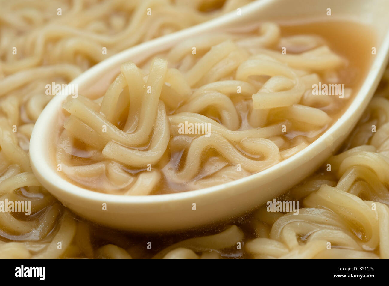 Cucchiaio di spaghetti ramen in ciotola di zuppa di Ramen. Foto Stock
