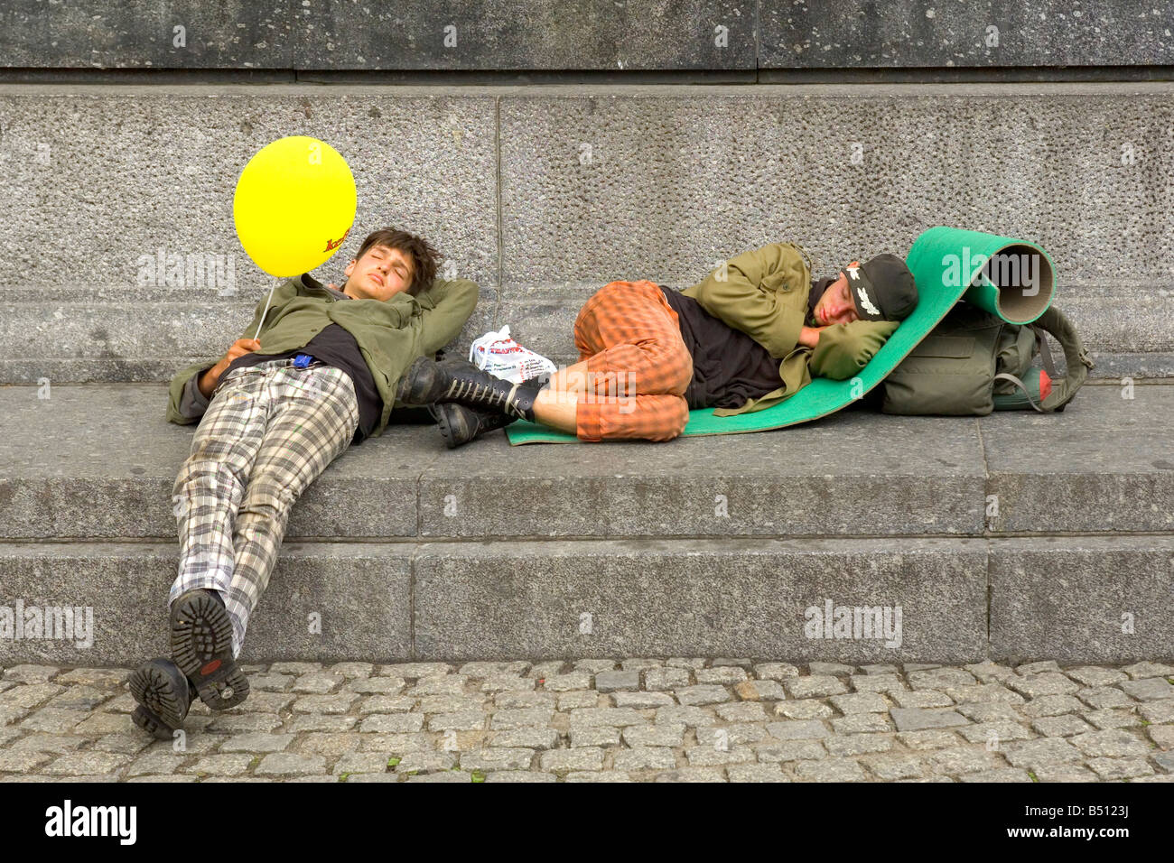 Due senzatetto ? Giovani addormentato ai piedi di Adam Mickiewicz monumento nella piazza del Mercato di Cracovia in Polonia. Foto Stock