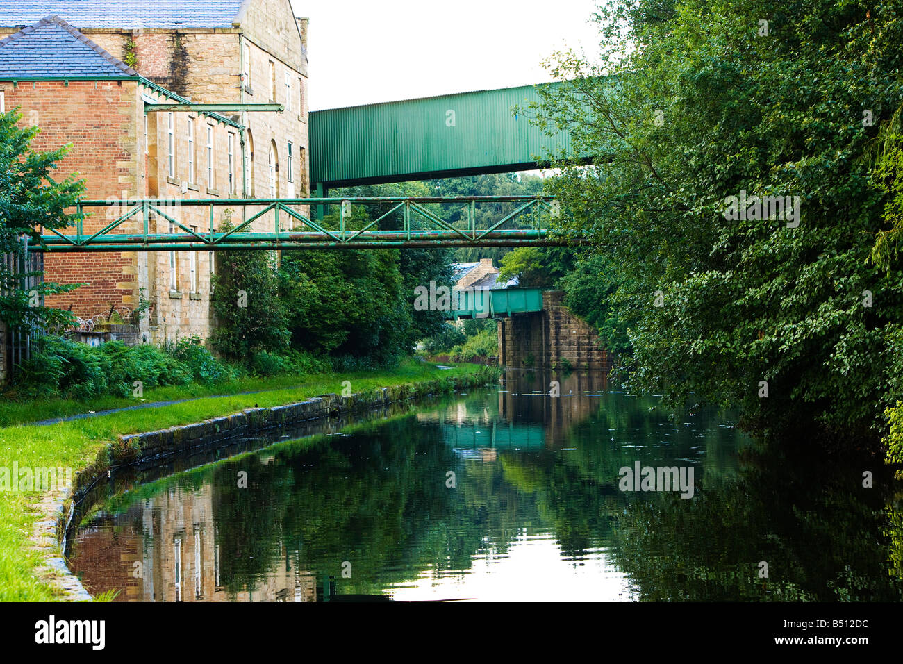 Vecchi magazzini e dei ponti che attraversano il Leeds Liverpool canal Foto Stock